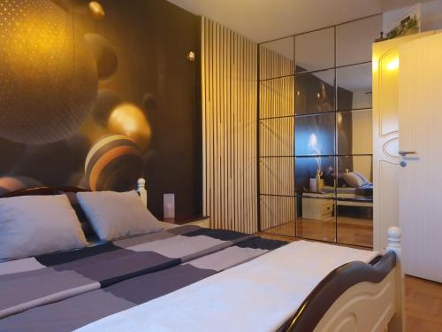 a bedroom with a bed and a large glass wall at Apartman River in Sremska Mitrovica