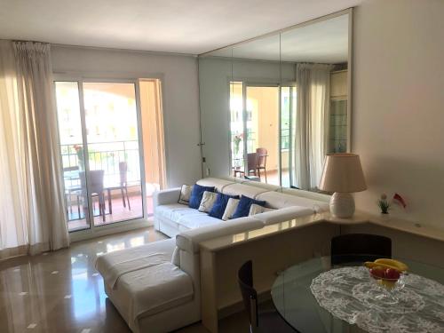 a living room with a couch and a table at Monaco F1 Port de Fontvieille refined apartment overlooking the garden, with pool access, 10 min from GP in Monte Carlo