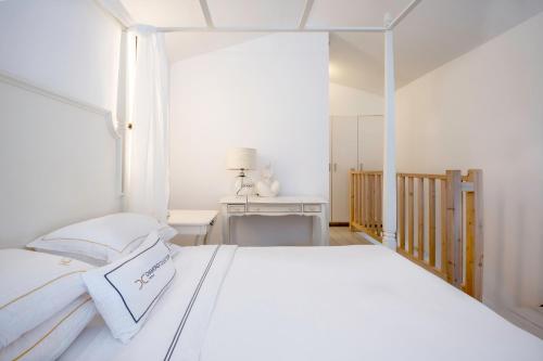 una camera bianca con letto bianco e scrivania di Diamond Deluxe Hotel - Adults Only a Città di Kos