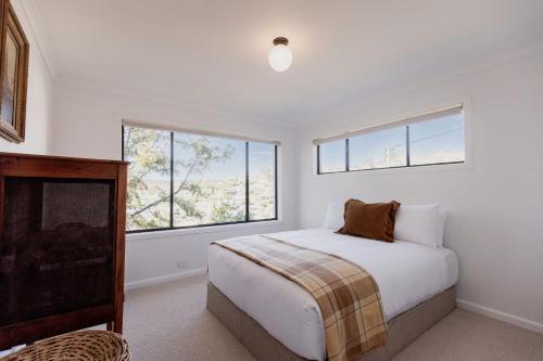 ein Schlafzimmer mit einem Bett und einem großen Fenster in der Unterkunft Trendy apartment in the heart of West Hobart in Hobart