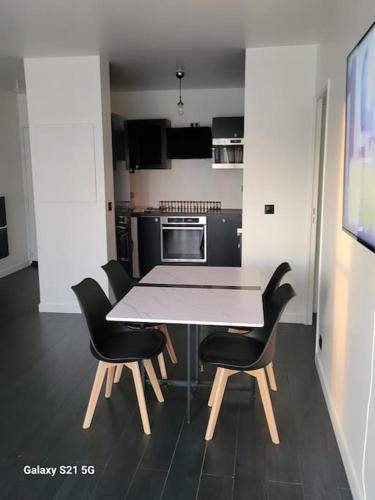 une cuisine avec une table et des chaises dans une pièce dans l'établissement Superbe T2, Paris, Stade de France, WIFI, Parking, à Saint-Denis