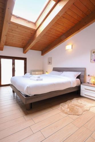 a large bed in a bedroom with a skylight at Primopiano - Di Vittorio in Sesto San Giovanni