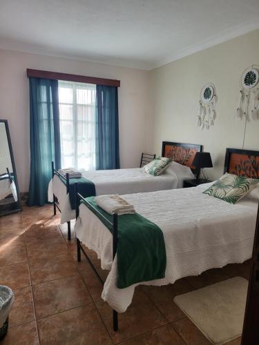 a bedroom with three beds and a window at Casa da Palmeira in Velas