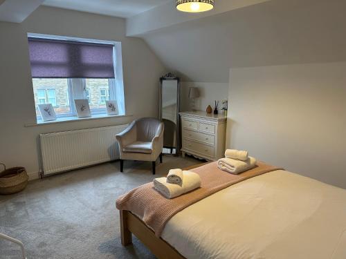 1 dormitorio con 1 cama, 1 silla y 1 ventana en King’s Road Apartments, en Harrogate