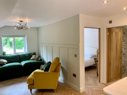een woonkamer met een groene bank en een gele stoel bij Deer View in Bishops Tawton