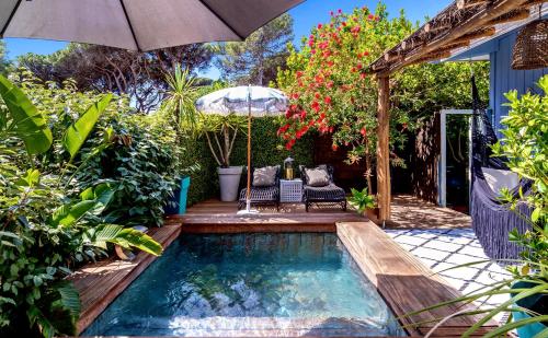 加桑的住宿－Casa Bambou An hidden gem near Saint Tropez with private pool，小型游泳池配有遮阳伞、椅子、桌子和遮阳伞