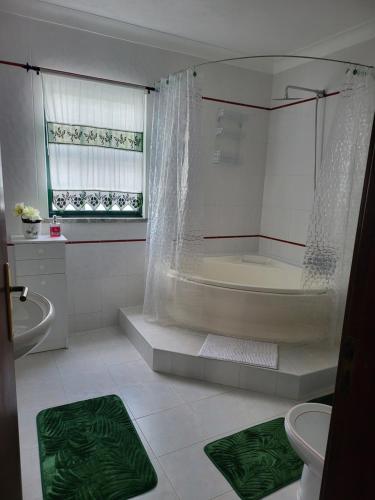 y baño con bañera, ducha y aseo. en Casa da Palmeira, en Velas