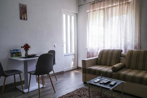 ein Wohnzimmer mit einem Sofa und einem Tisch in der Unterkunft Cozy spacious apartment in Peja