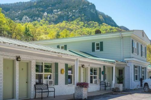 a white house with a mountain in the background at Geneva Hotel & Tiki Bar in Lake Lure