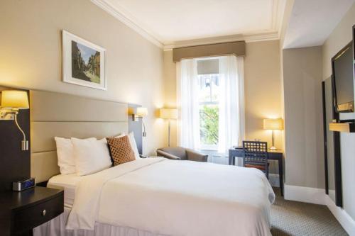 una camera d'albergo con un letto bianco e una finestra di Newbury Guest House a Boston