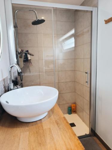 une salle de bain avec un lavabo blanc et une douche dans l'établissement Chambre St Saturnin petit déjeuner compris, à Saint-Saturnin