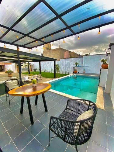 un patio con tavolo, sedie e piscina di Casa los Abuelos a Xalapa