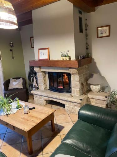 a living room with a fireplace and a couch at La Paulerie in Wacquinghen