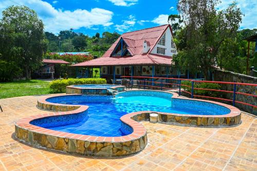 - une piscine dans une cour avec une maison dans l'établissement EcoHotel Colibrí, à Luna Park
