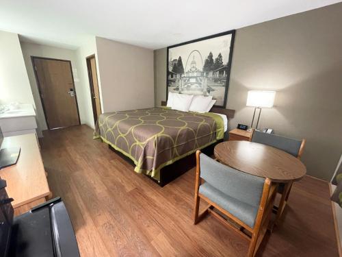 a small hotel room with a bed and a table at Super 8 by Wyndham Eureka/Six Flags Nearby in Eureka
