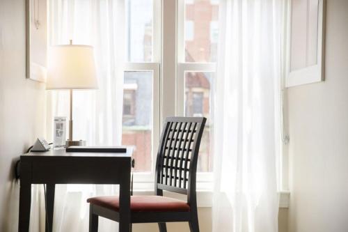 a desk with a chair next to a window at Newbury Guest House in Boston