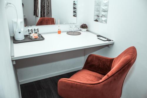 a chair sitting in front of a vanity with a mirror at Studioapartment Black & White in Velika Gorica