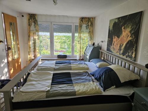 a large bed in a bedroom with a large window at Unter Linden in Bad Bocklet
