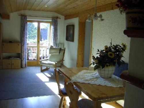 a living room with a table and a chair at Gästehaus Riki Oberschmid in Steinbach am Attersee