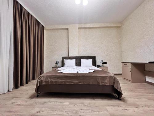 1 dormitorio con 1 cama y TV en Avrasya Hotel en Baku
