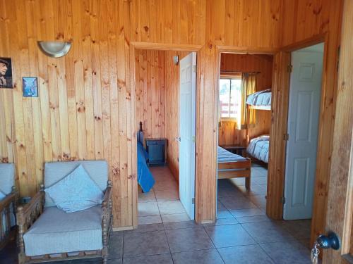 um quarto com paredes de madeira e um quarto com uma cama em Cabañas algarrobo em Algarrobo