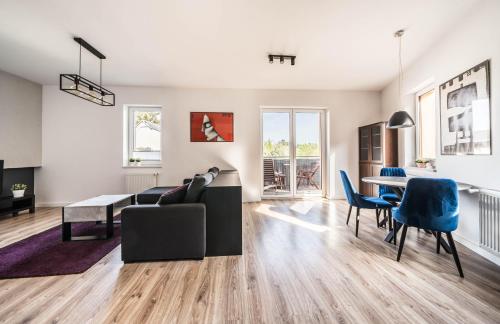 a living room with a couch and a table and chairs at Apartament Belvedere Ławica Airport in Poznań