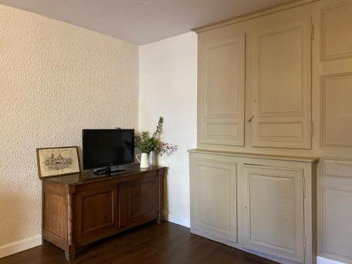 - un salon avec une télévision sur un meuble en bois dans l'établissement Le virage pour un séjour rural, à Fresnes-sur-Apance