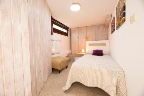 1 dormitorio con cama blanca y paredes de madera en Apartamento Vila do Mar, en Baiona
