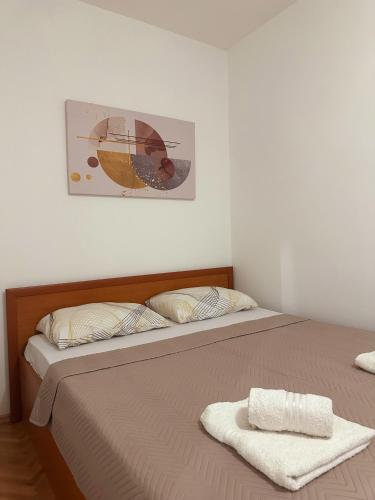 een slaapkamer met een bed en een foto aan de muur bij Lina's Apartment in Skopje