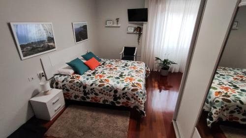 um quarto com uma cama e uma cómoda ao lado de uma cama em CasacheloCangas em Cangas