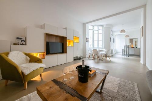 - un salon avec un canapé et une table avec des verres à vin dans l'établissement Superbe Loft 67 m2 Bastille Marais, à Paris