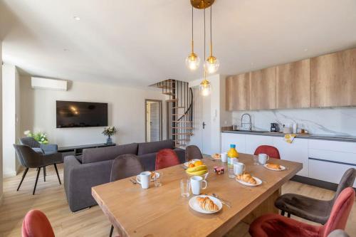 Il comprend une cuisine et un salon avec une table en bois. dans l'établissement BRP Cannes Center, Top floor Luxurious Apartment I, 4 bedrooms+3 bathrooms, à Cannes