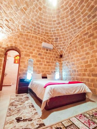 a bedroom with a bed in a brick wall at فيلا البرج-Villa Elburj in Tunis