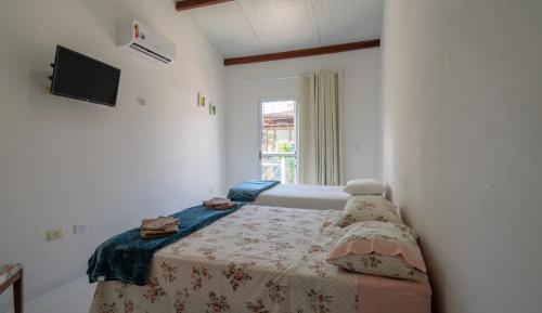 Habitación pequeña con cama y ventana en Suites Praia de Juquehy en Juquei