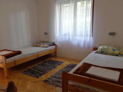 a small room with two beds and a window at Apartmani Marina in Labin