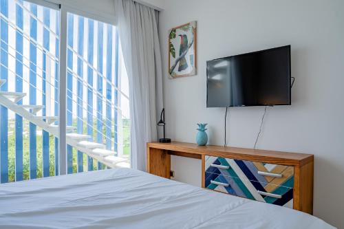 1 dormitorio con 1 cama y TV de pantalla plana en Xeliter Cana Rock Punta Cana, en Punta Cana