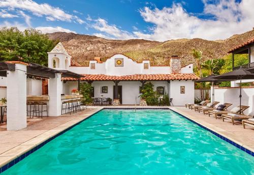 a villa with a swimming pool and a house at Lucille Palm Springs in Palm Springs