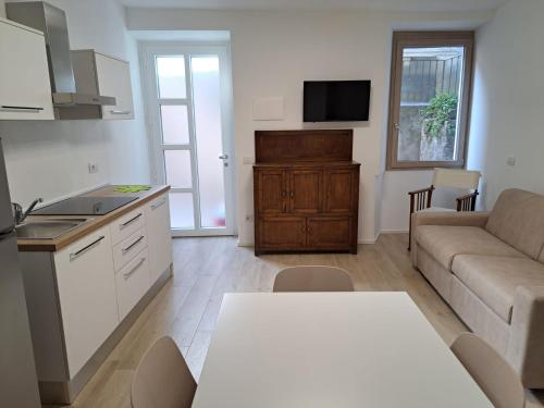 a kitchen and living room with a couch and a table at CASA n 61 in Dervio