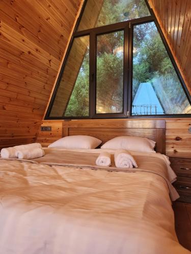 cottage vizitori في باتومي: سرير في غرفة مع نافذة كبيرة
