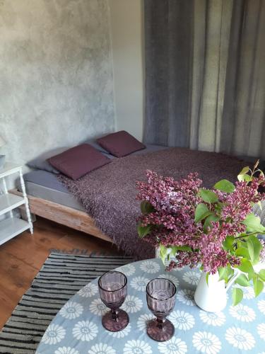 a bedroom with a bed and a table with flowers at Mellene 1 bedroom house in nature & hot tube in Turaida