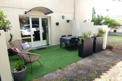 a patio with a table and chairs on grass at Appartement 4 personnes bord mer in Yves