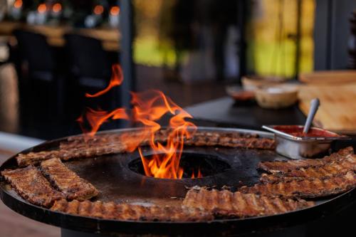 a grill with a bunch of food on fire at Pensiunea Hardic in Horodnic de Sus
