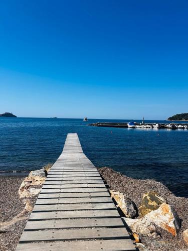 a wooden pier over the water on a beach at Spirito del mare in Portoferraio