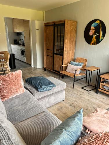 a living room with two couches and a painting on the wall at Vakantiehuisje Martina 11 in Vlissingen