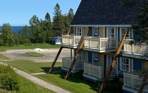 a house with a slide on the side of it at Hébergement Fort Prével in Saint-Georges-de-Malbaie