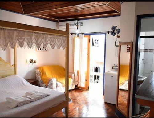 a bedroom with a canopy bed and a bathroom at Pouso das Gerais in Tiradentes