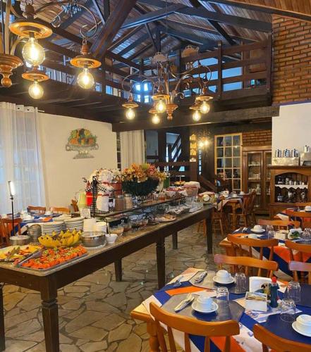 a restaurant with a long table with food on it at Pouso das Gerais in Tiradentes