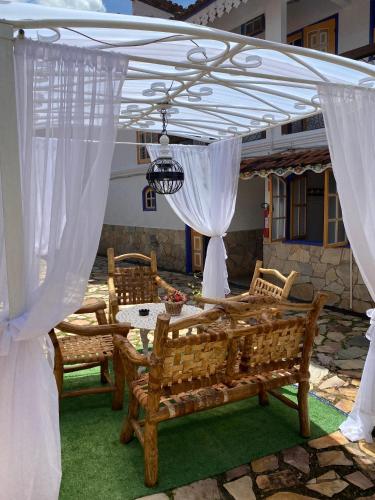 a pavilion with a table and chairs under a white canopy at Pouso das Gerais in Tiradentes
