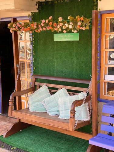 a porch swing with pillows and flowers on it at Pouso das Gerais in Tiradentes