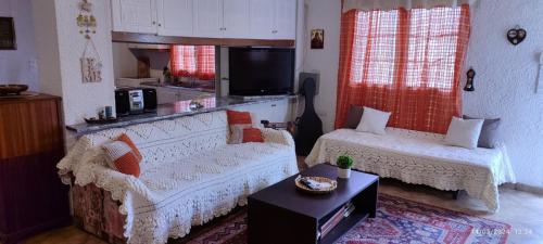 ein Wohnzimmer mit einem Sofa und einem Tisch in der Unterkunft Kineta Farmhouse in Kineta